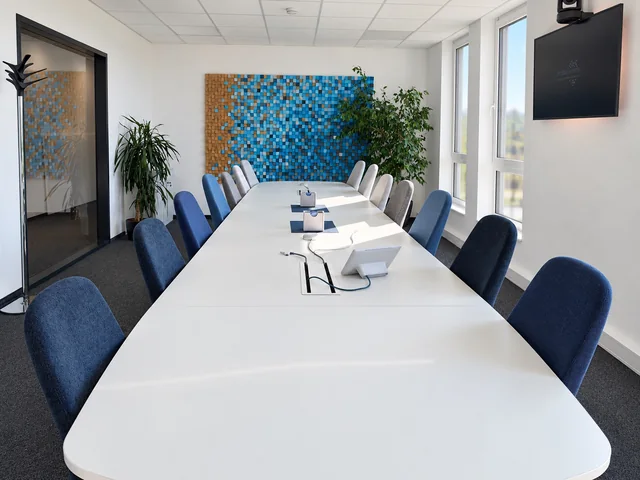 Besprechungsraum von innos mit der blau gestalteten Markenwand.